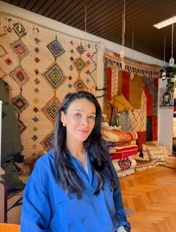 Nadia, fundadora de Maison Mazhar, ante una selección de alfombras bereberes.